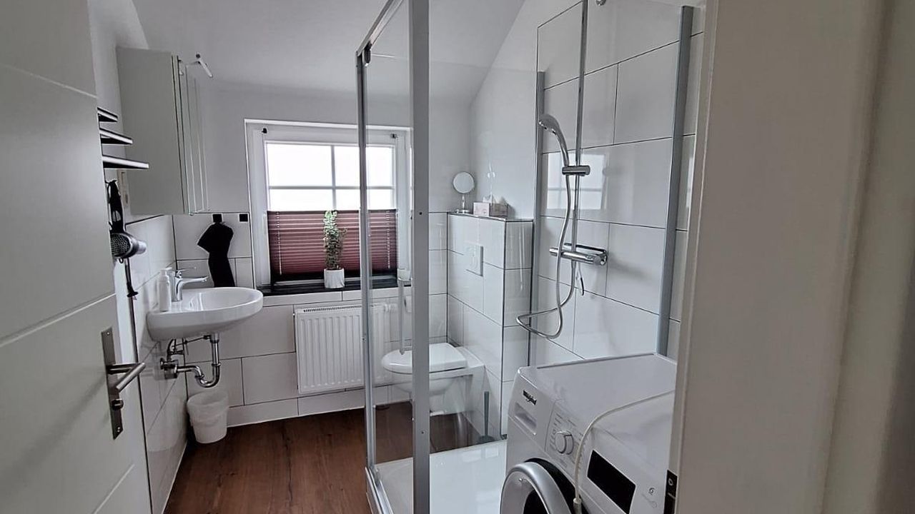 Badezimmer mit Dusche und Waschmaschine Badezimmer mit Dusche und Waschmaschine